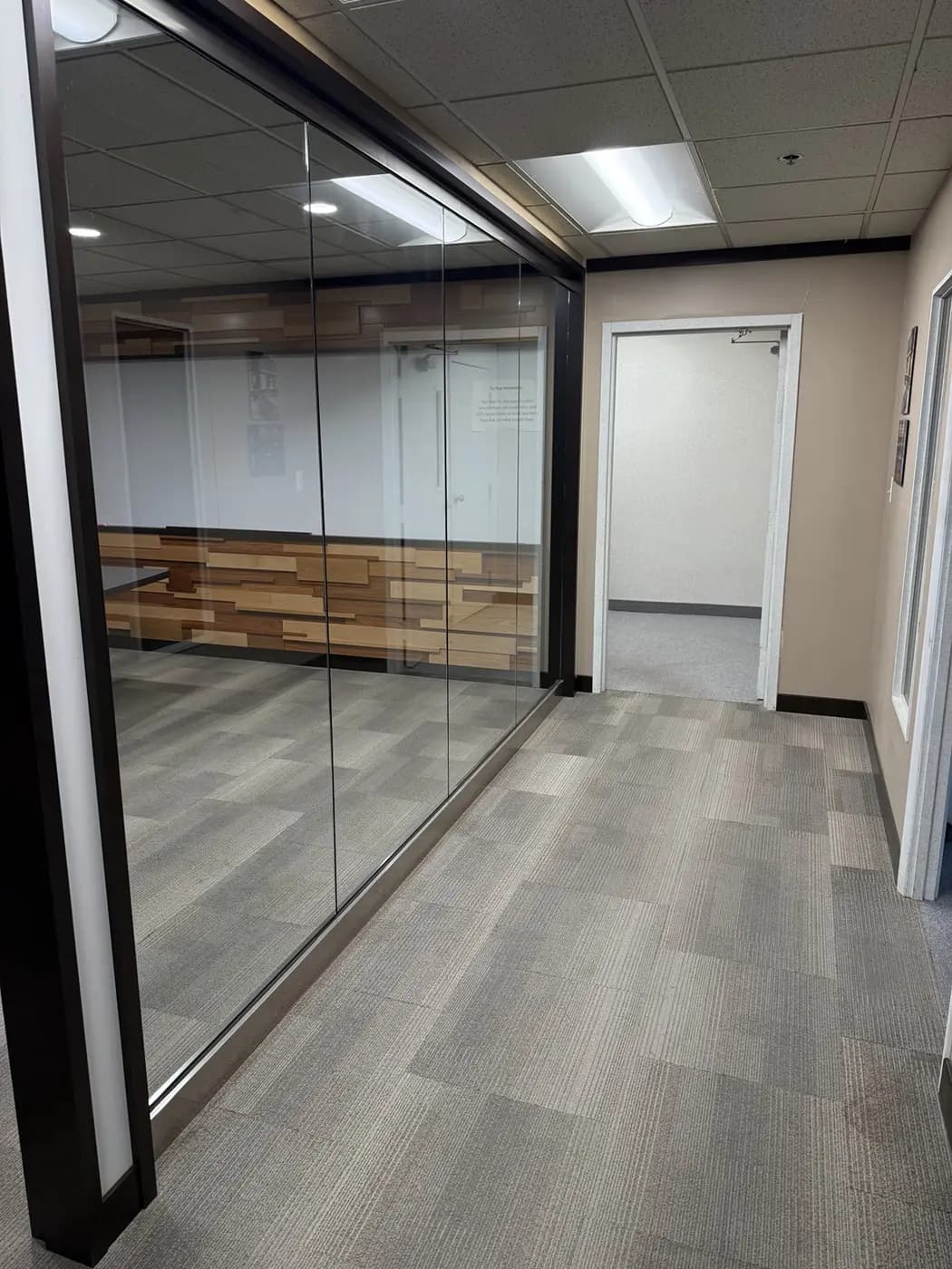 Finished commercial office corridor with carpet and interior glass